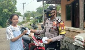 Bhabinkamtibmas Cikeusal Sambang Desa Bagikan Masker ke Warga