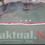Unik, Bendera Raksasa Terbentang di Pantai Kuri Maros